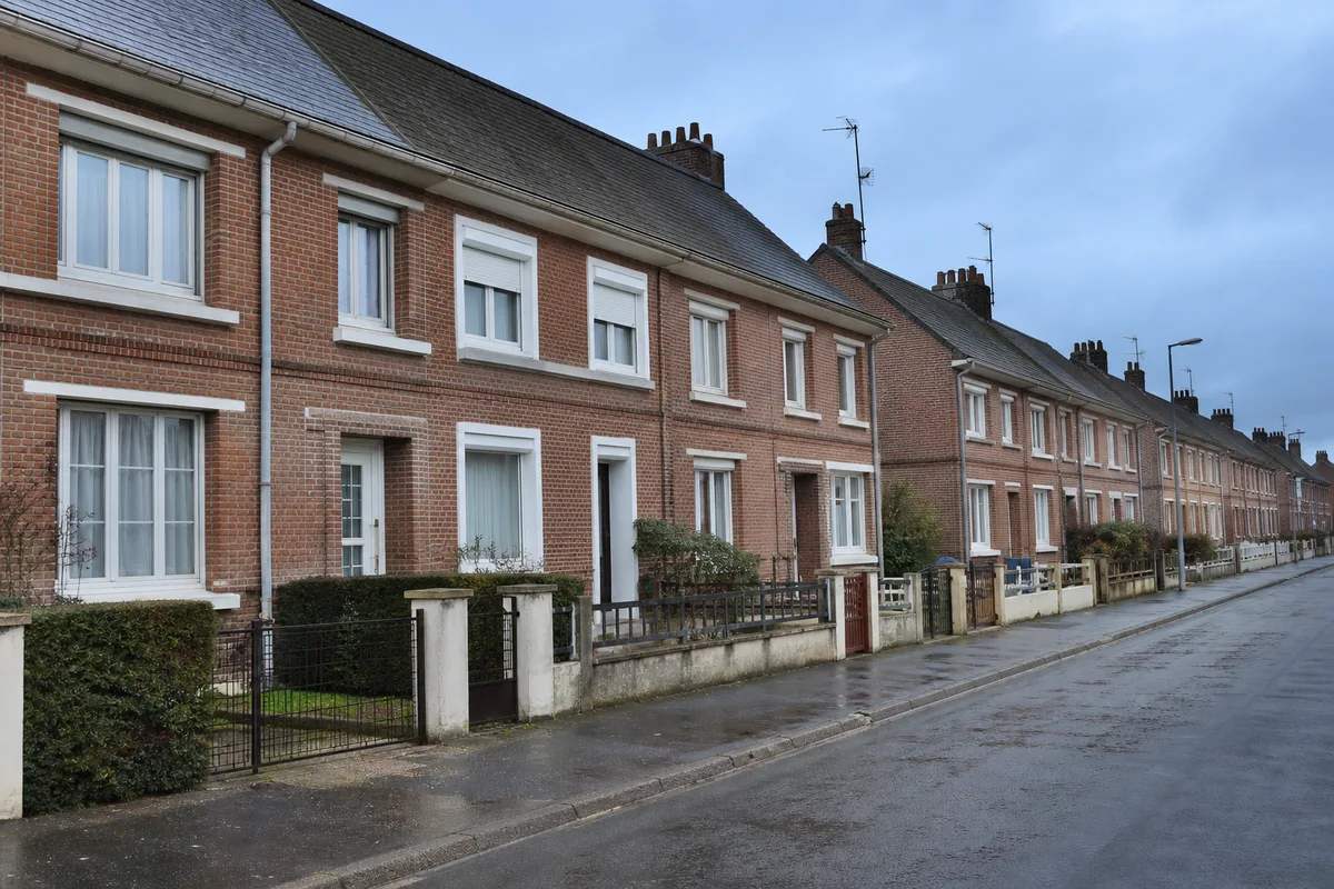 Rue de maisons en briques de la reconstruction à Péronne sous un ciel picard